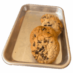 Three Thumbprints cookies are arranged in a row on a rectangular metal baking tray with raised edges, set against a plain white background.